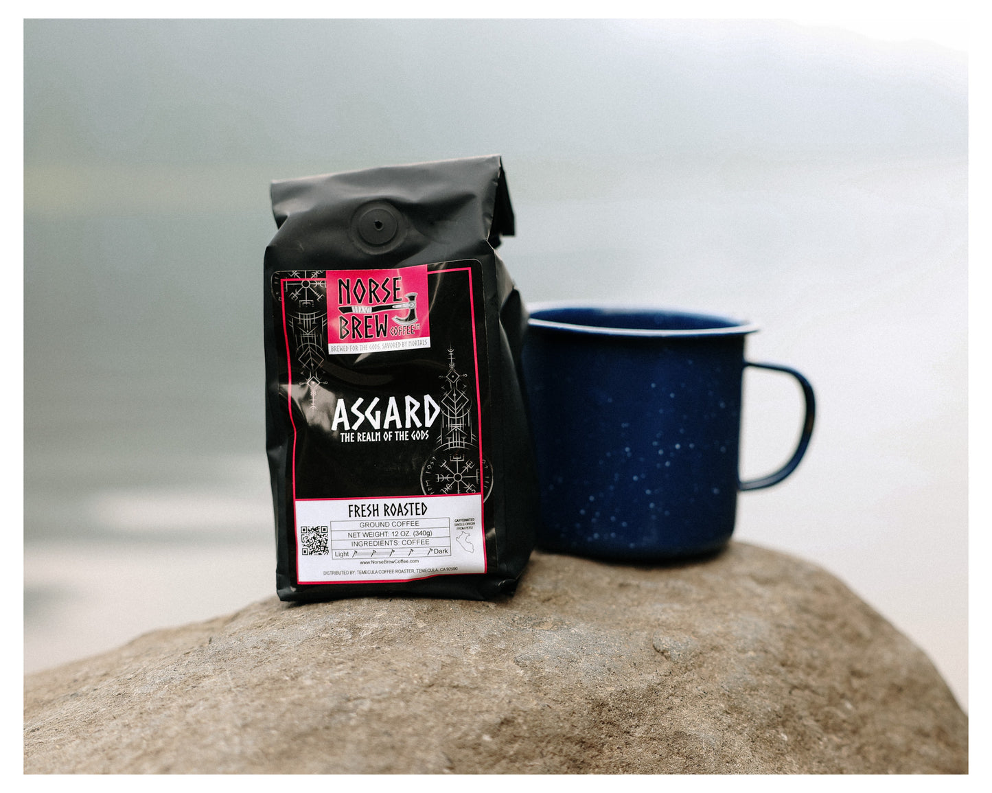 Bag of Asgard Medium Roast Whole Bean Coffee Sourced from Piura, Peru on a rock next to a coffee cup